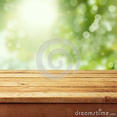 Empty wooden deck table with foliage bokeh Stock Photo