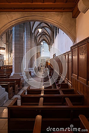 Empty wooden pews or chairs inside Gothic, medieval church in Europe. Wide angle, no people Editorial Stock Photo