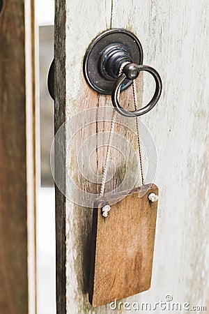 Empty wooden plate on metal door knob. Place for logo, text. Don`t disturb sign Stock Photo