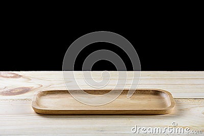 Empty wooden plate on wood table isolated on black Stock Photo