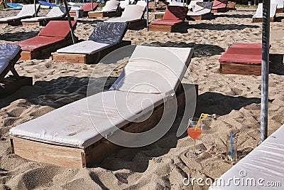 Empty wooden sun loungers on the beach Stock Photo