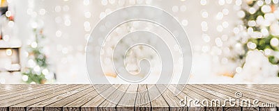 Empty woooden table top with abstract warm living room decor with christmas tree string light blur background with snow,Holiday Stock Photo