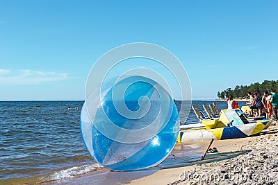 Empty zorb on the inshore waves, water activities, Zorbing extreme attraction for beach vacationers Editorial Stock Photo