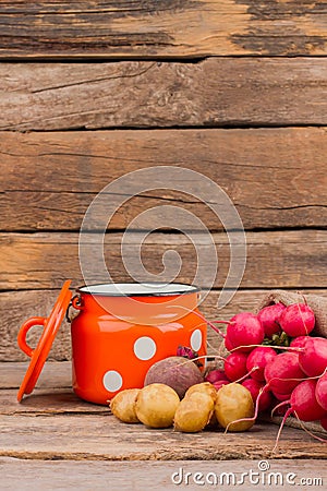 Enamelware Cup and vegetables still life. Stock Photo