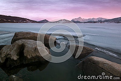 Enchanted view of frozen Campotosto lake in winter at sunset, Abruzzo Stock Photo