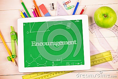 Encouragement against students desk with tablet pc Stock Photo