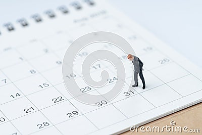 End of month for salary man concept, miniature people businessman office guy standing and looking at number 31 date, waiting to g Stock Photo