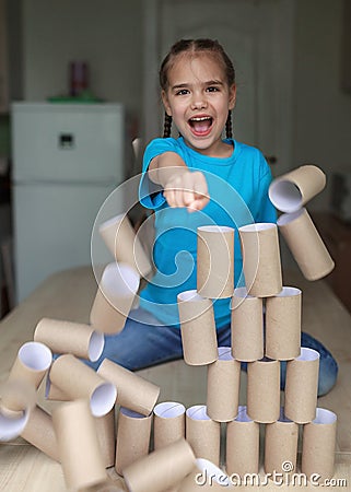 End of quarantine, happy girl beating the wall of paper toilette rolls, kept after lockdown, new normal Stock Photo