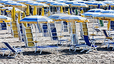 End of summer - Parasols and sun loungers closed on the beach Stock Photo
