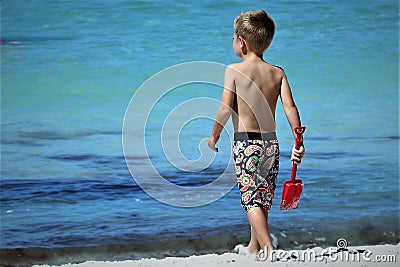 Young boy on water edge of beach in Florida Editorial Stock Photo