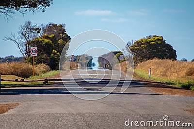 Endless straight road in Australian Outback with hot sun causing a Fata Morgana Stock Photo