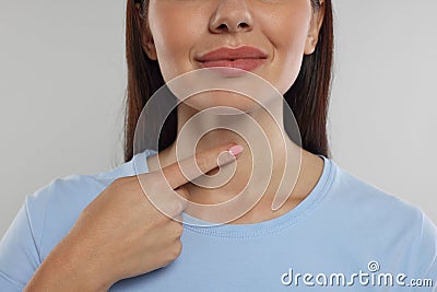 Endocrine system. Woman doing thyroid self examination on light grey background, closeup Stock Photo