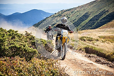 Enduro bikers crossing road in Carpathian mountains. Editorial Stock Photo