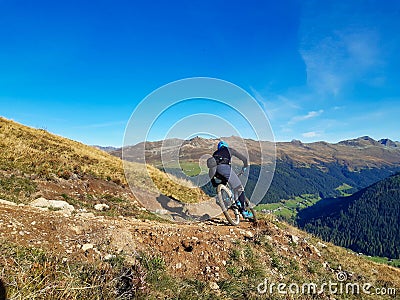 Enduro ride with steep bend, banked curve, Swiss Mountain Alps at Davos Switzerland. With blue clear sky and great view Stock Photo