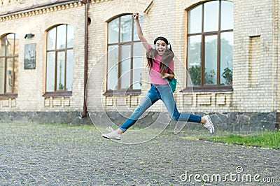 Energetic child girl jumping dancing listening music headphones, never stop concept Stock Photo
