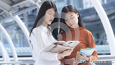 Energetic optimistic teen girls with stationary and book and read. Stock Photo