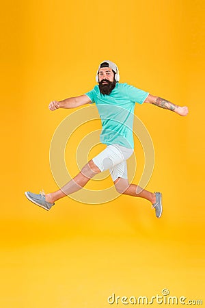 Energetic and upbeat music for leisure. Energetic hipster jumping high on yellow background. Bearded man in mid air Stock Photo