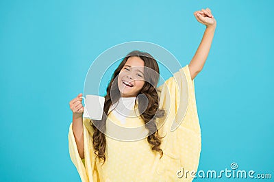 Energize morning. small kid blue background. little girl drink cocoa or milk before sleeping. cosy and fluffy pajama Stock Photo