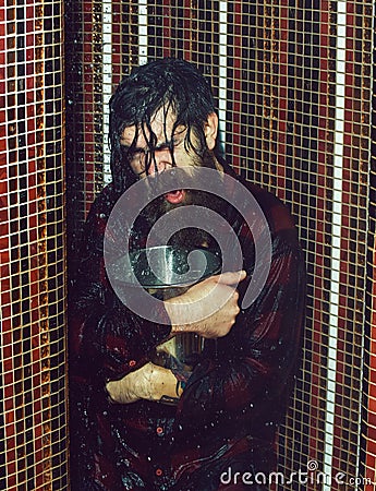 Energized handsome man, bearded hipster with beard and moustache in red checkered shirt wet with water in shower with Stock Photo