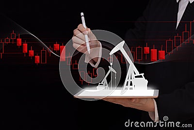 Energy crisis concept, tablet with oil pumps and chart of the oil index in the hands of a businessman, exchange oil prices, OPEC b Stock Photo