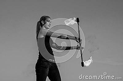 Energy and elegance. Sexy girl twirl flaming baton blue sky. Fire show. Art show or performance. Baton twirling. Holiday Stock Photo