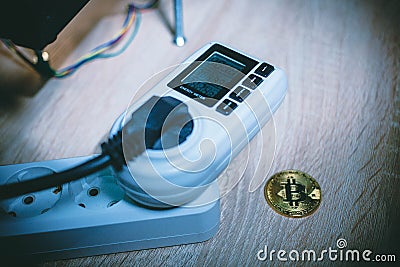 Energy meter next to coin bitcoin Stock Photo
