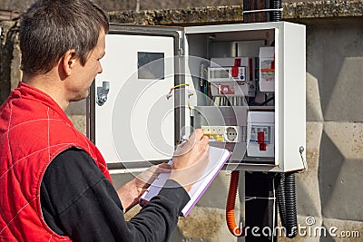 An energy sales worker takes readings of electricity meters Stock Photo