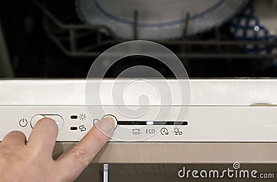 Energy saving concept. Selecting the economy mode on the dishwasher. Stock Photo