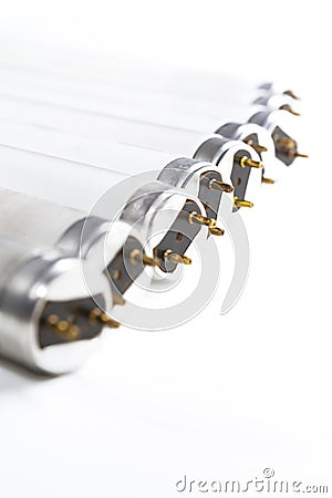Energysaving Concepts. Arranged Line of Used Obsolete Fluorescence Lamps Placed on Pure White Stock Photo