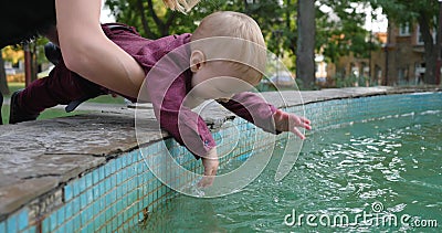 Enfant curieux essayant de toucher l'eau de fontaine à la nature banque de vidéos Enfant curieux essayant de toucher l'eau de fontaine à la nature banque de vidéos