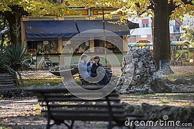 Engaged couple sitting at the park Editorial Stock Photo