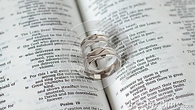 Engagement marriage wedding rings white gold on open Bible Book. Blessing and gift from God Jesus Christ biblical concept Stock Photo