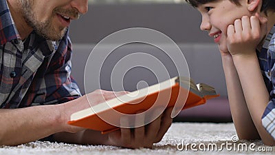 Engendrez le conte de fées de lecture au fils se trouvant sur le plancher, éducation préscolaire de loisirs à la maison banque de vidéos Engendrez le conte de fées de lecture au fils se trouvant sur le plancher, éducation préscolaire de loisirs à la maison banque de vidéos