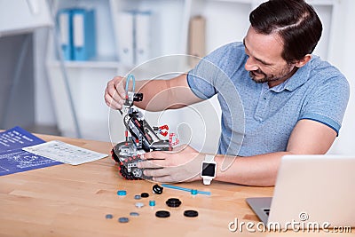 Engeneer in blue t-shirts constructing droid Stock Photo