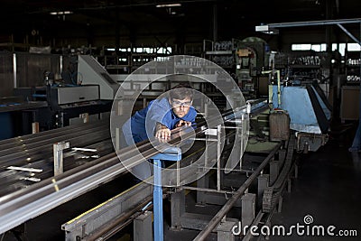 Engineer adjusts a machine in factory Stock Photo