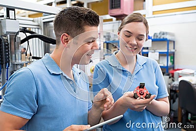 Engineer And Apprentice Examining Component In Factory Stock Photo