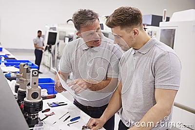 Engineer And Apprentice Discussing Job Sheet In Factory Stock Photo
