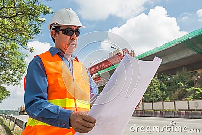 Engineer or Architect wear white Helmet working or reading Construction Plan Stock Photo