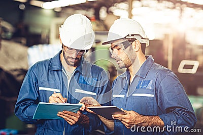 Engineer audit worker working team together with safety uniform and white helmet to work in industry factory handle tablet and Stock Photo