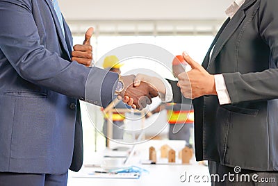 Engineer and businessman partnership shake hand and thumb up gesture to joy successful agreement in engineering, Architectural or Stock Photo