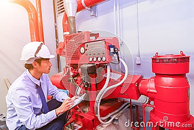 Engineer check red generator pump for water sprinkler piping and fire alarm control. Stock Photo