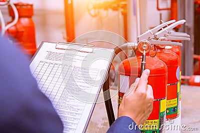 Engineer checking fire extinguisher. Stock Photo