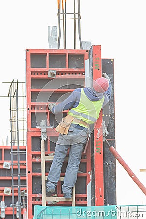 An engineer is climbing up the stairs at the constraction site Editorial Stock Photo