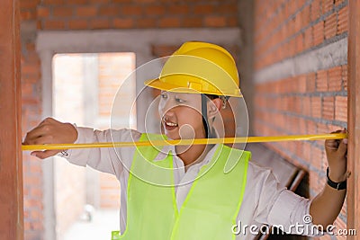 Engineer concept The constructing worker concentrating with measuring the width of the door with the yellow tape rule Stock Photo