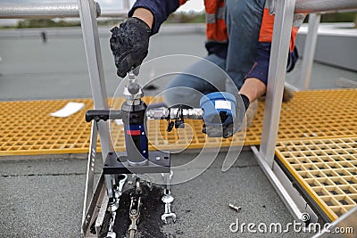 Engineer conducting using pull machinery testing chemical set fall arrest fall restraint abseiling anchor point Stock Photo