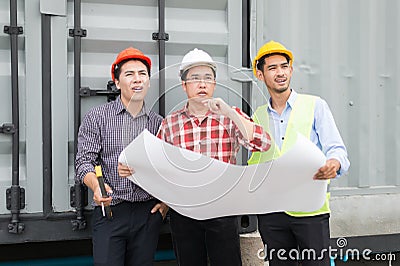 Engineer and construction team wearing safety helmet and blueprint on hand. they are reviewing material and construction process Stock Photo