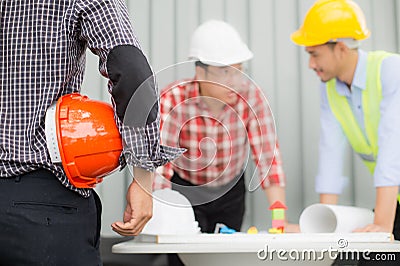 Engineer and construction team wearing safety helmet and looking blueprint on the table Stock Photo