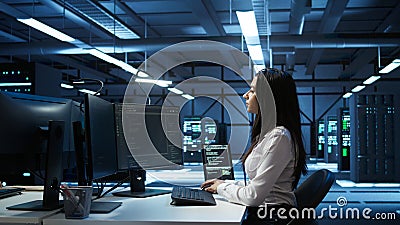 Engineer in data center sitting down at desk, installing software Stock Photo