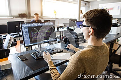 Engineer designer working on desktop computer in factory Stock Photo