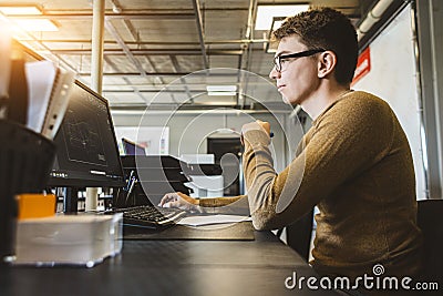 Engineer designer working on desktop computer in factory Stock Photo